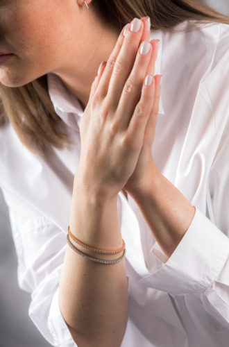 Nahaufnahme einer Frau mit Fokus auf ihre Arme mit Armbändern